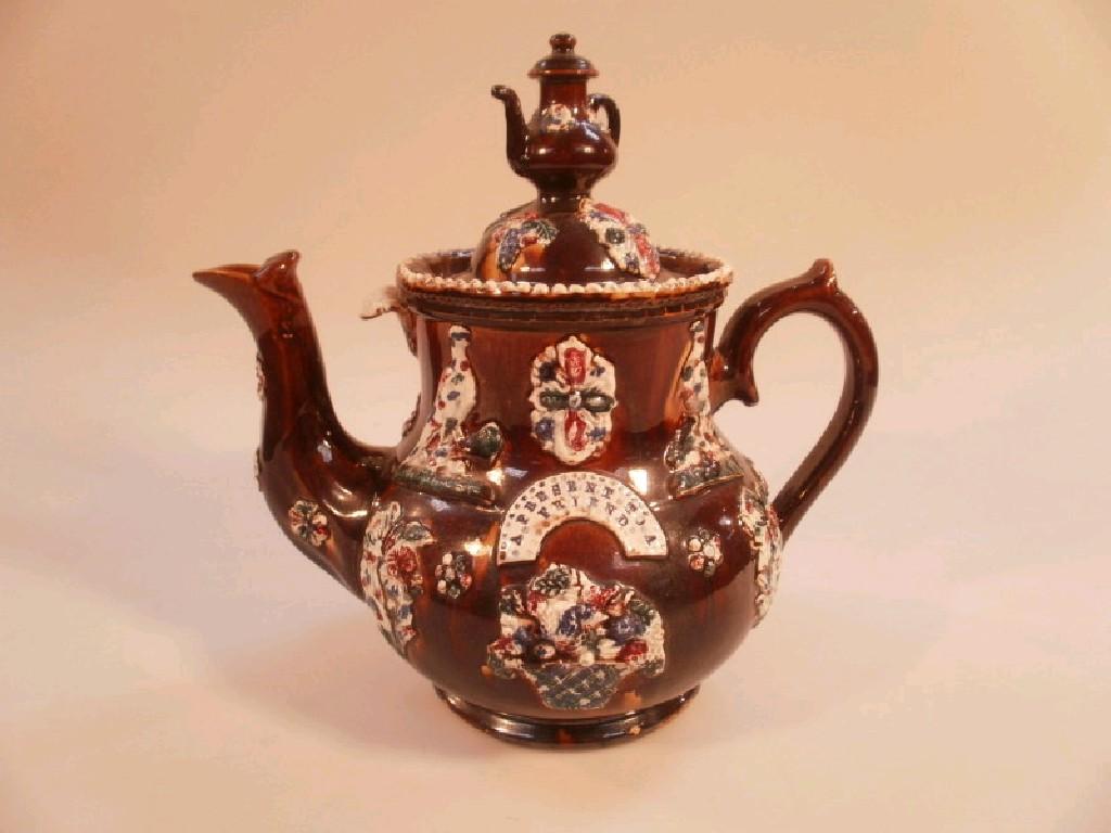 Appraisal: A late Victorian Measham bargeware treacle glaze teapot with applied