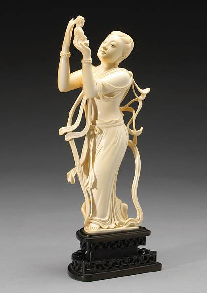 Appraisal: A carved and reticulated ivory Buddhist female figure Wearing flowing