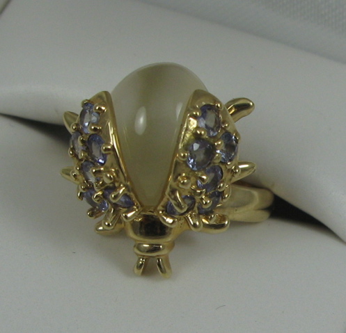 Appraisal: MOONSTONE TANZANITE AND FOURTEEN KARAT GOLD RING set with round-cut