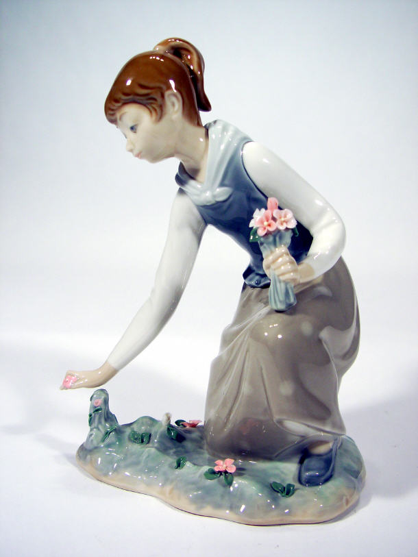 Appraisal: Lladro figurine of a young girl picking flowers printed factory