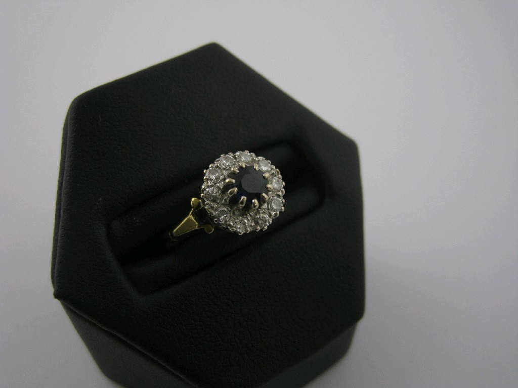 Appraisal: A Sapphire and Diamond Cluster Ring the central circular-cut sapphire