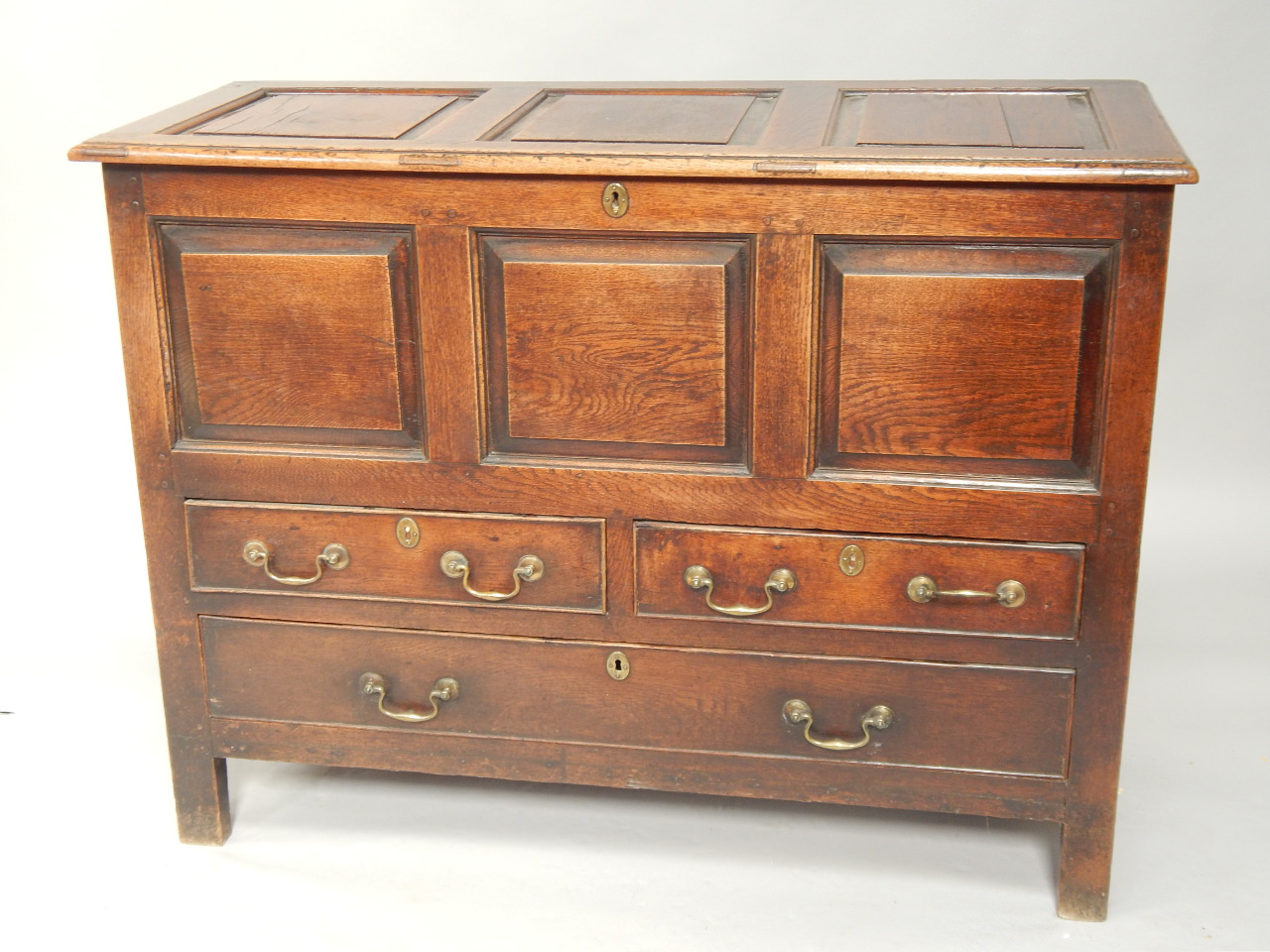 Appraisal: A George III oak mule chest with triple panelled hinge