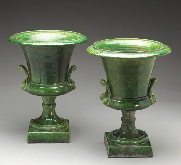 Appraisal: A pair of French Neoclassical style green glazed faience urns