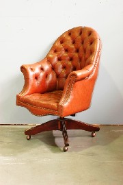 Appraisal: A brown leather upholstered swivel button down arm chair