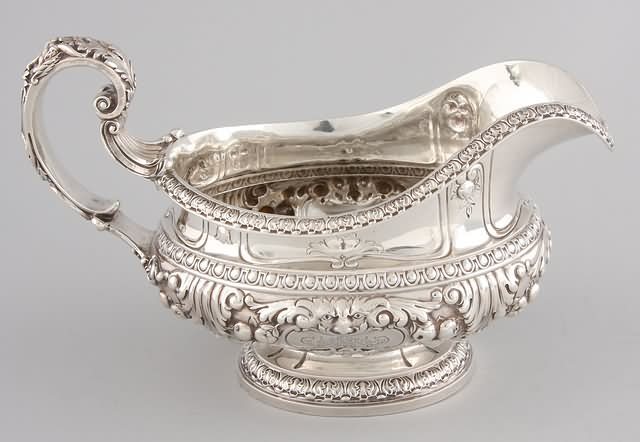 Appraisal: Gravy sauceboat with figural handle and faces on both sides