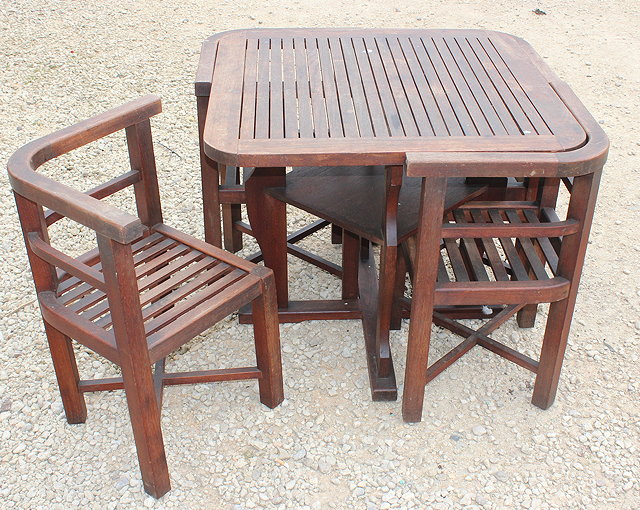 Appraisal: A TEAK SQUARE SLATTED TABLE AND NESTING CHAIRS manufactured by