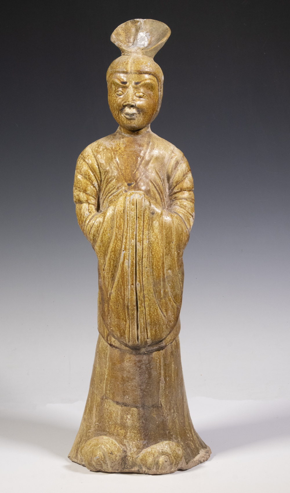 Appraisal: CHINESE TANG DYNASTY LARGE STONEWARE FIGURE OF AN ATTENDANT Solid