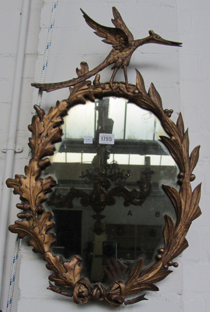 Appraisal: A giltwood carved wall mirror of oval form late th