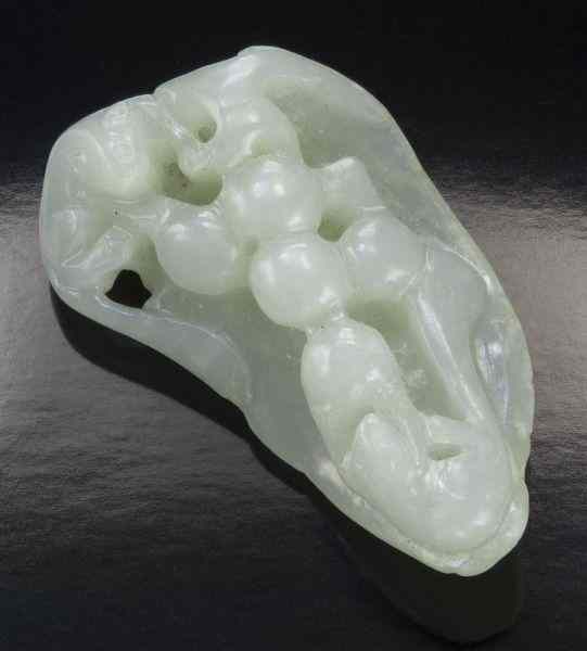 Appraisal: Chinese Qing carved jade toggledepicting a squirrel and grapes on