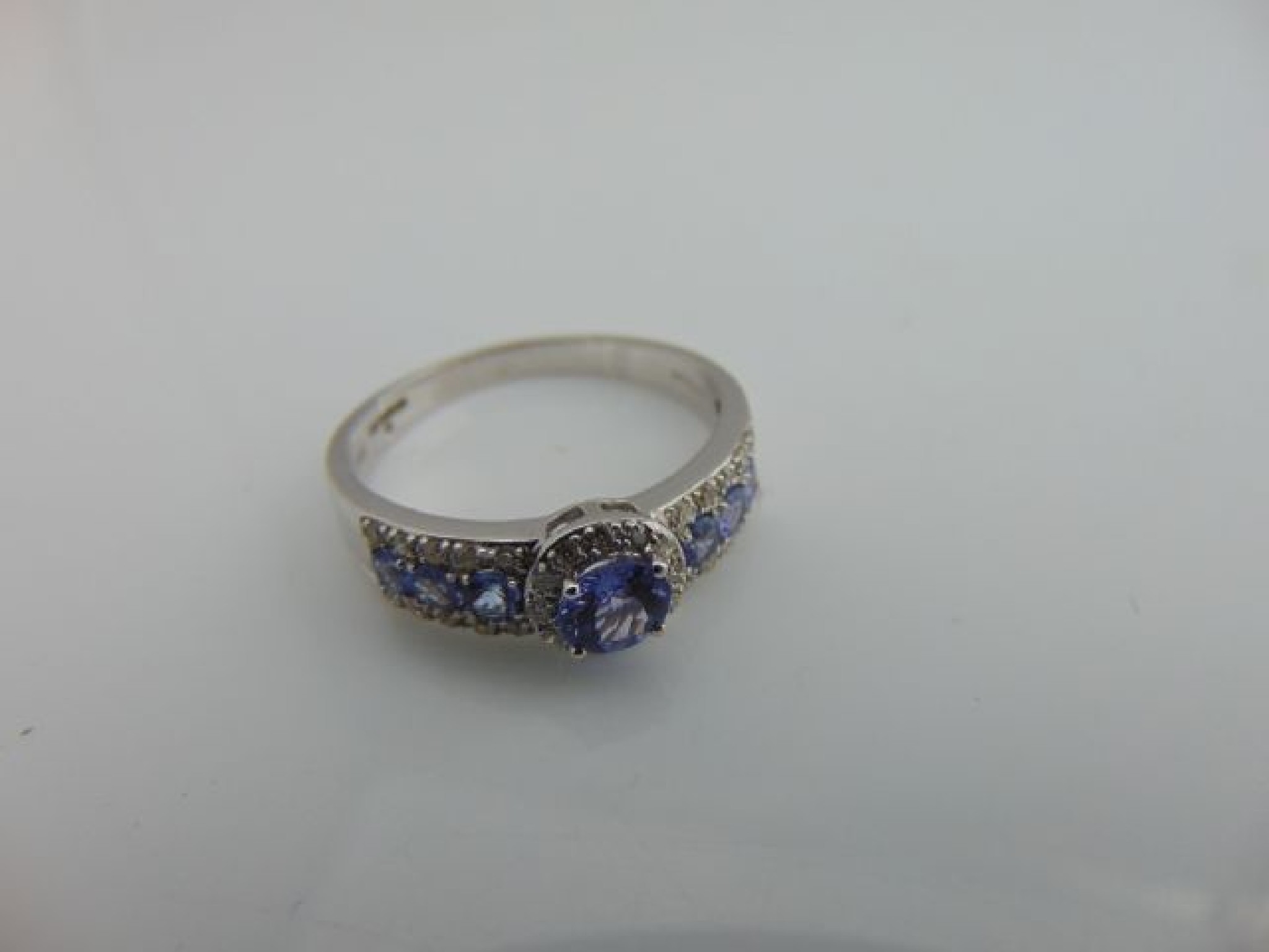 Appraisal: A tanzanite and diamond ring centred with a round mixed-cut