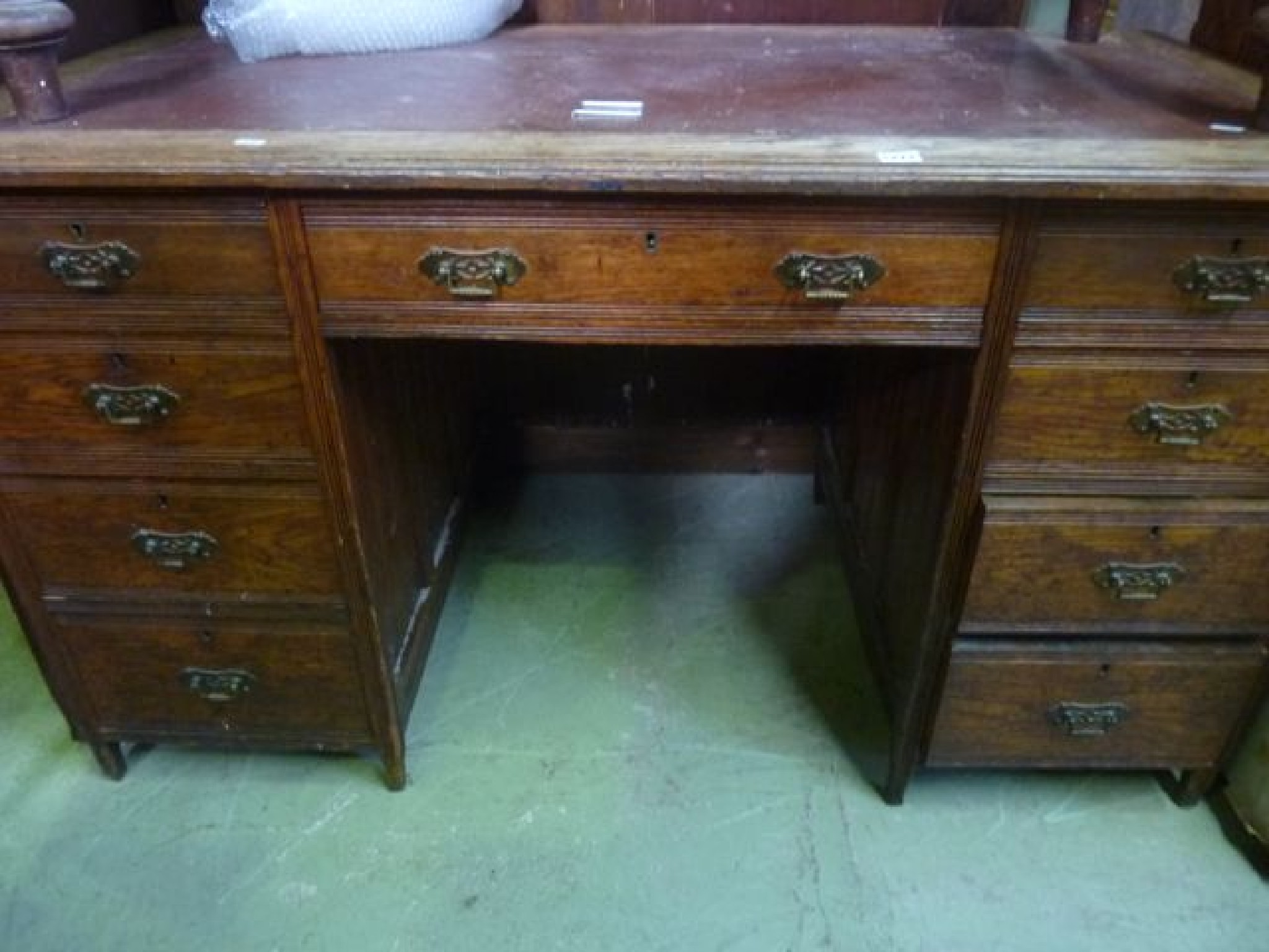 Appraisal: A late Victorian oak kneehole twin pedestal writing desk of