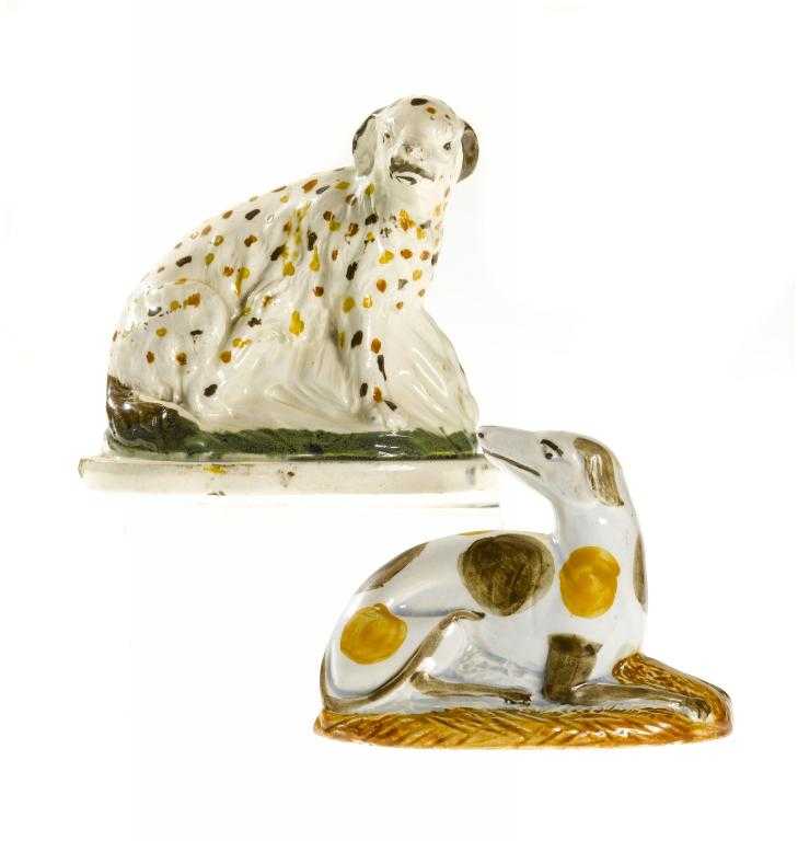 Appraisal: A CREAMWARE MODEL OF A DOG seated on a green