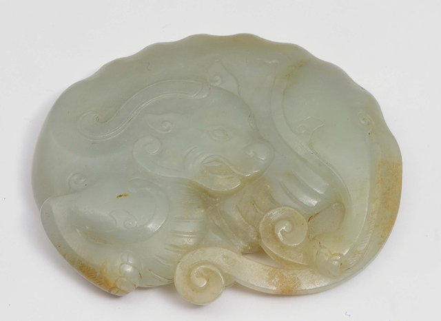 Appraisal: A CHINESE JADE CARVING OF A SINGLE HORNED BUDDHIST LION