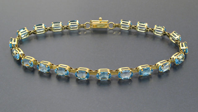 Appraisal: BLUE TOPAZ AND TWELVE KARAT GOLD LINE BRACELET set with