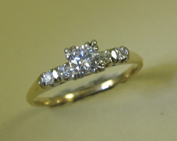 Appraisal: DIAMOND AND FOURTEEN KARAT GOLD RING centering a round-cut diamond