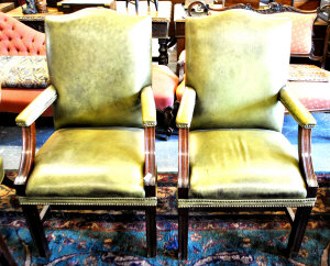 Appraisal: A pair of green leather upholstered Gainsborough style elbow chairs