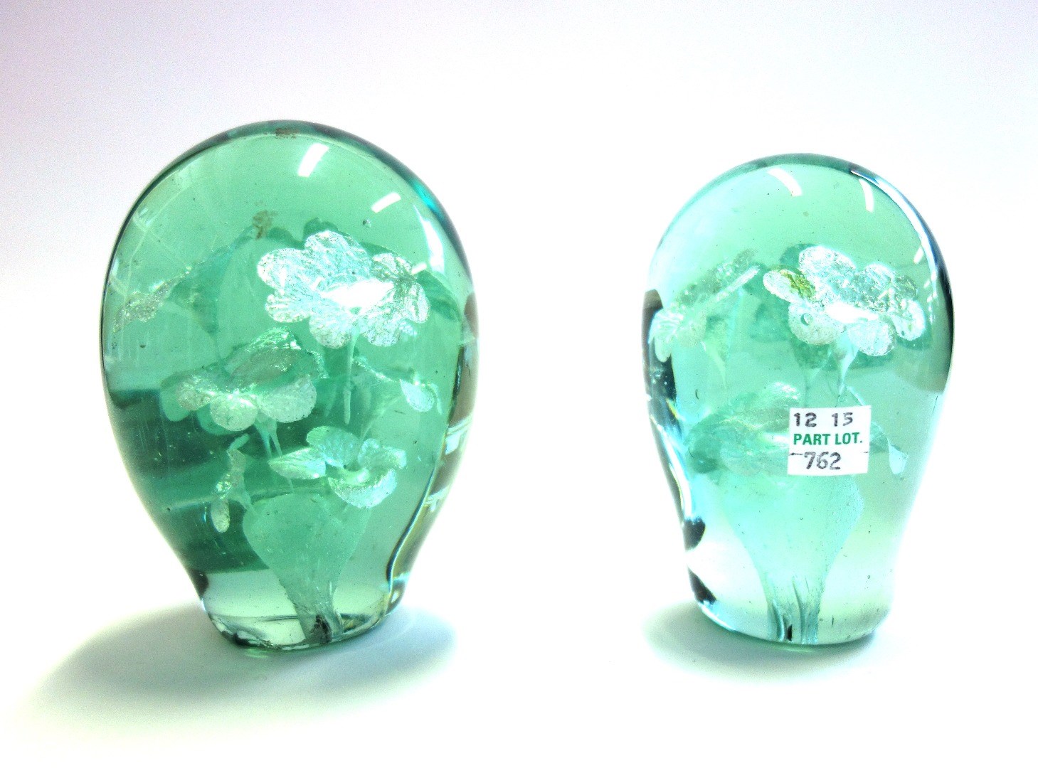 Appraisal: Two Victorian green glass dump paperweights each with floral inclusions