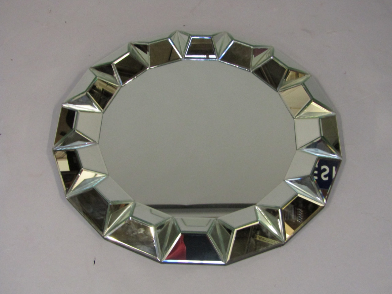 Appraisal: A circular glass wall mirror with a faceted glass border