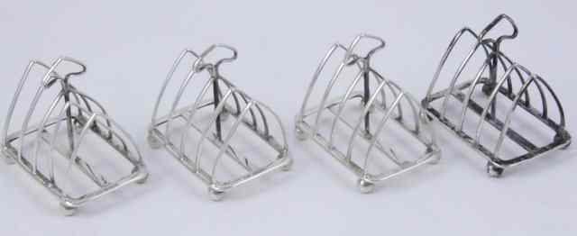 Appraisal: Four silver toast racks HA Sheffield with triangular divisions on