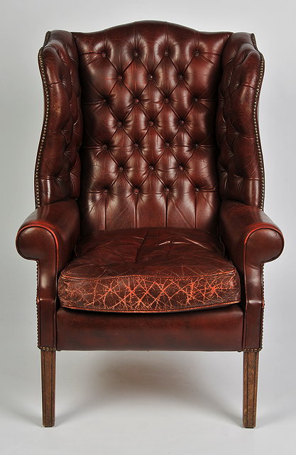 Appraisal: A GEORGE III STYLE LEATHER UPHOLSTERED WINGBACK ARMCHAIR on square