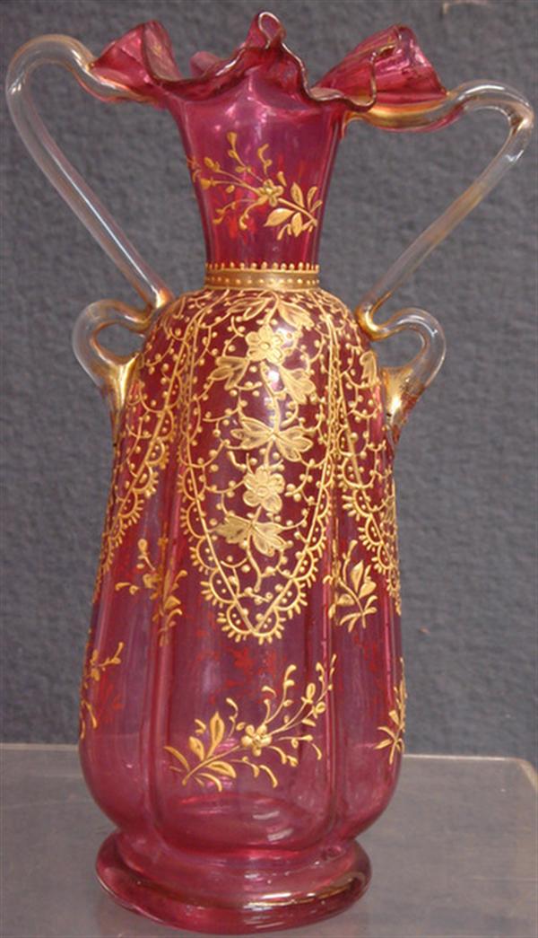 Appraisal: Cranberry glass ruffled top vase clear applied handles raised gold