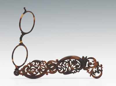 Appraisal: A Carved Tortoiseshell Lorgnette Carved reticulated case houses a swivel