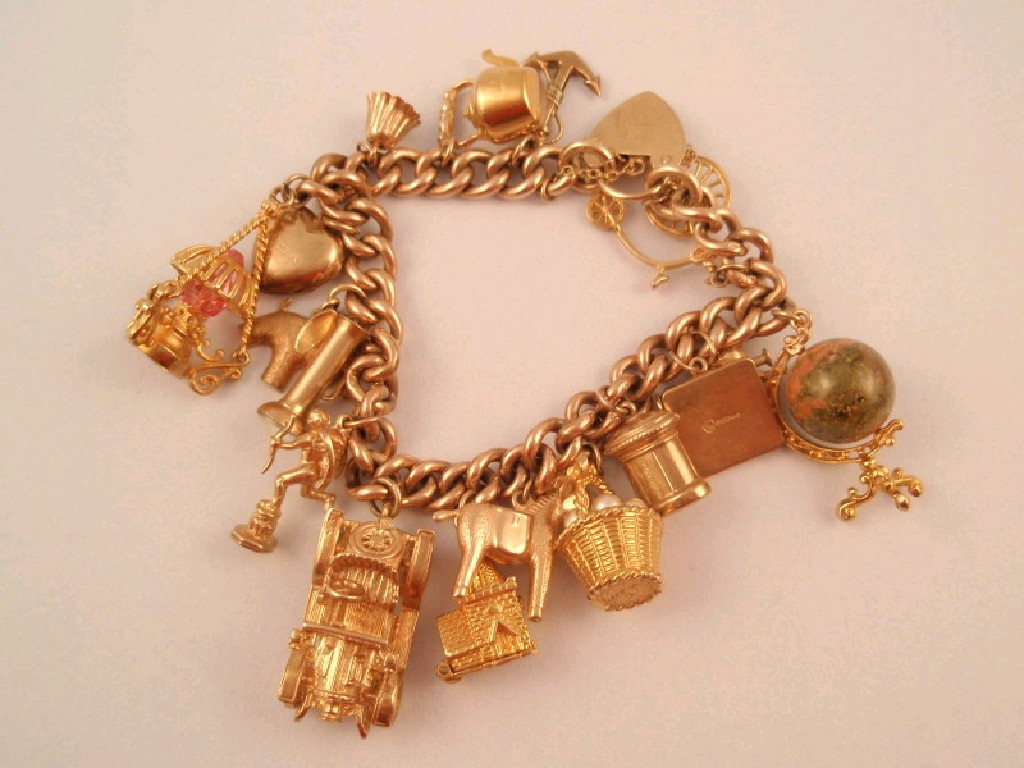 Appraisal: A ct gold curb link charm bracelet with seventeen charms