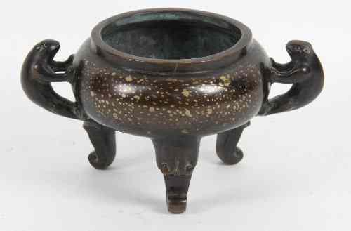 Appraisal: A Chinese bronze censer with gold splash decoration twin handles