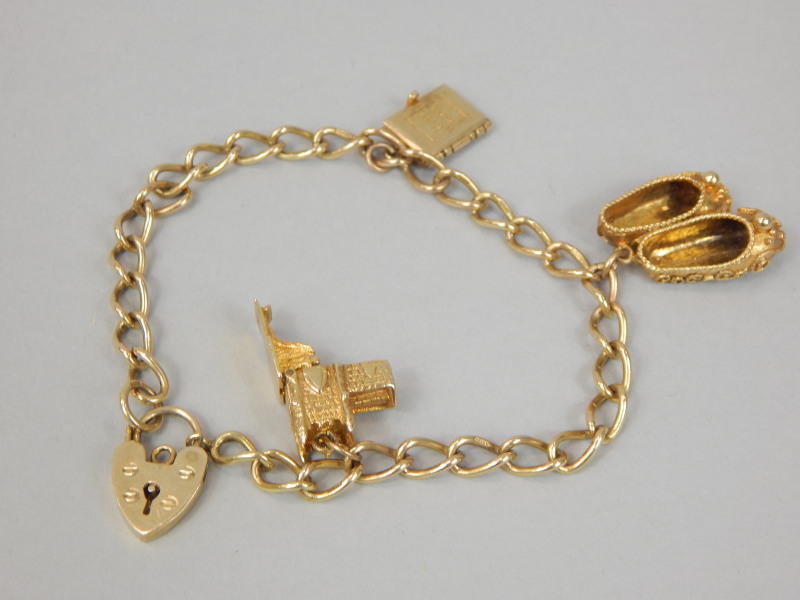 Appraisal: A ct gold charm bracelet with three charms a church