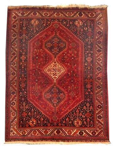 Appraisal: A SHIRAZ RED GROUND CARPET decorated a triple central medallion