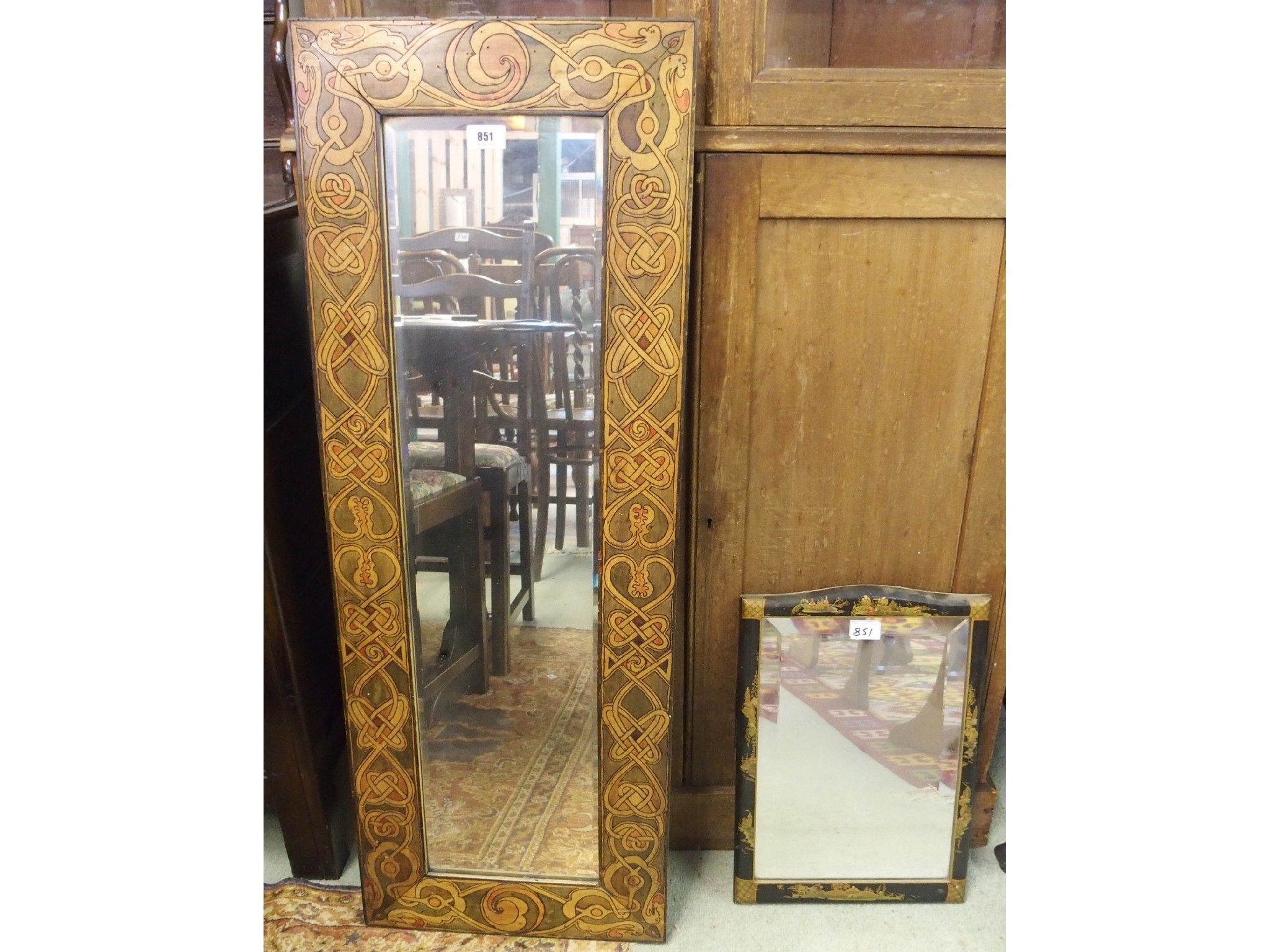 Appraisal: A black lacquered mirror and Celtic design stained wall mirror