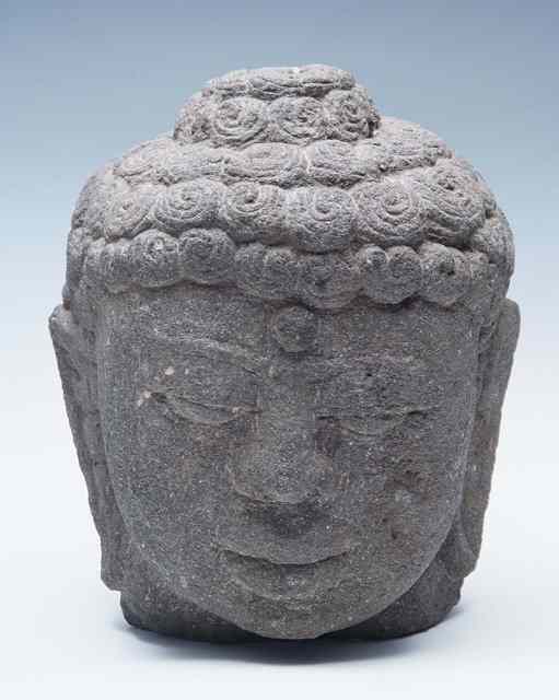 Appraisal: AN EAST JAVANESE VOLCANIC STONE HEAD OF A BUDDHA with