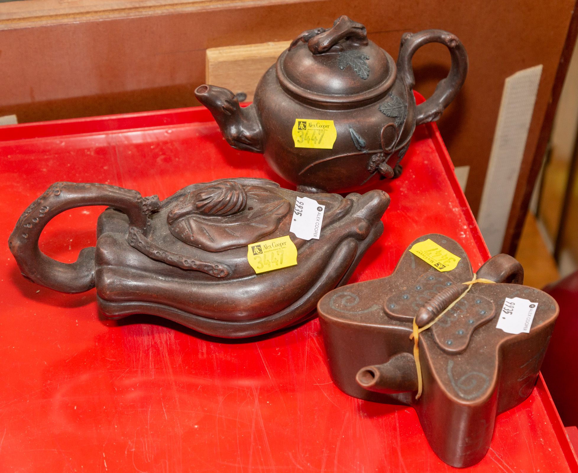 Appraisal: THREE YIXING TEAPOTS Includes butterfly in H squash blossom in