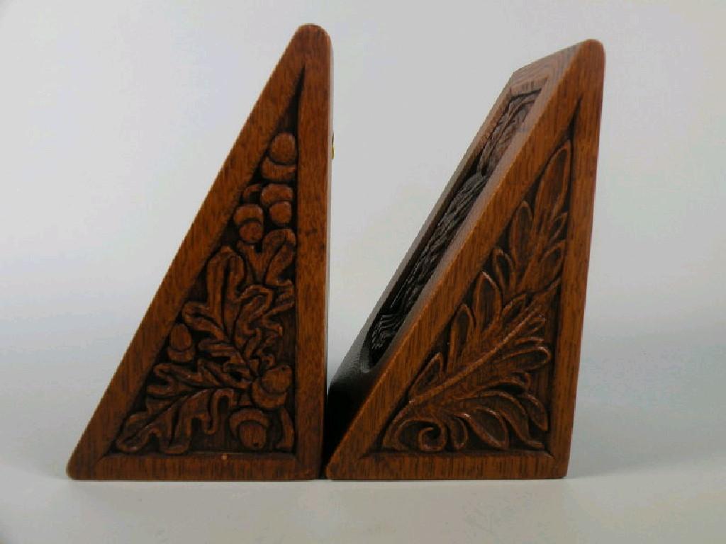 Appraisal: A pair of oak bookends each of triangular form carved