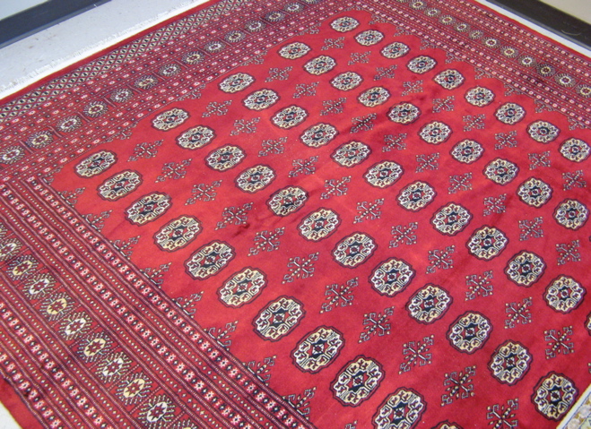 Appraisal: PAKISTANI BOKHARA CARPET overall Turkoman gol design on crimson ground