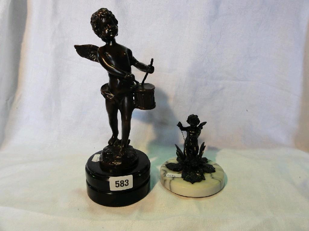 Appraisal: A bronze figure of a winged cherub playing a drum