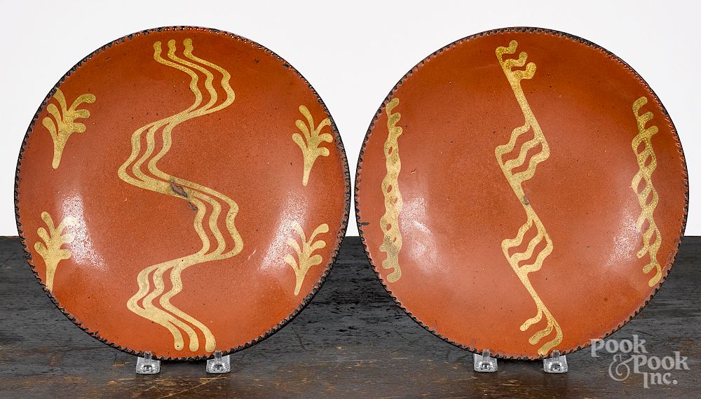 Appraisal: Two Pennsylvania slip decorated redware plates Two Pennsylvania slip decorated