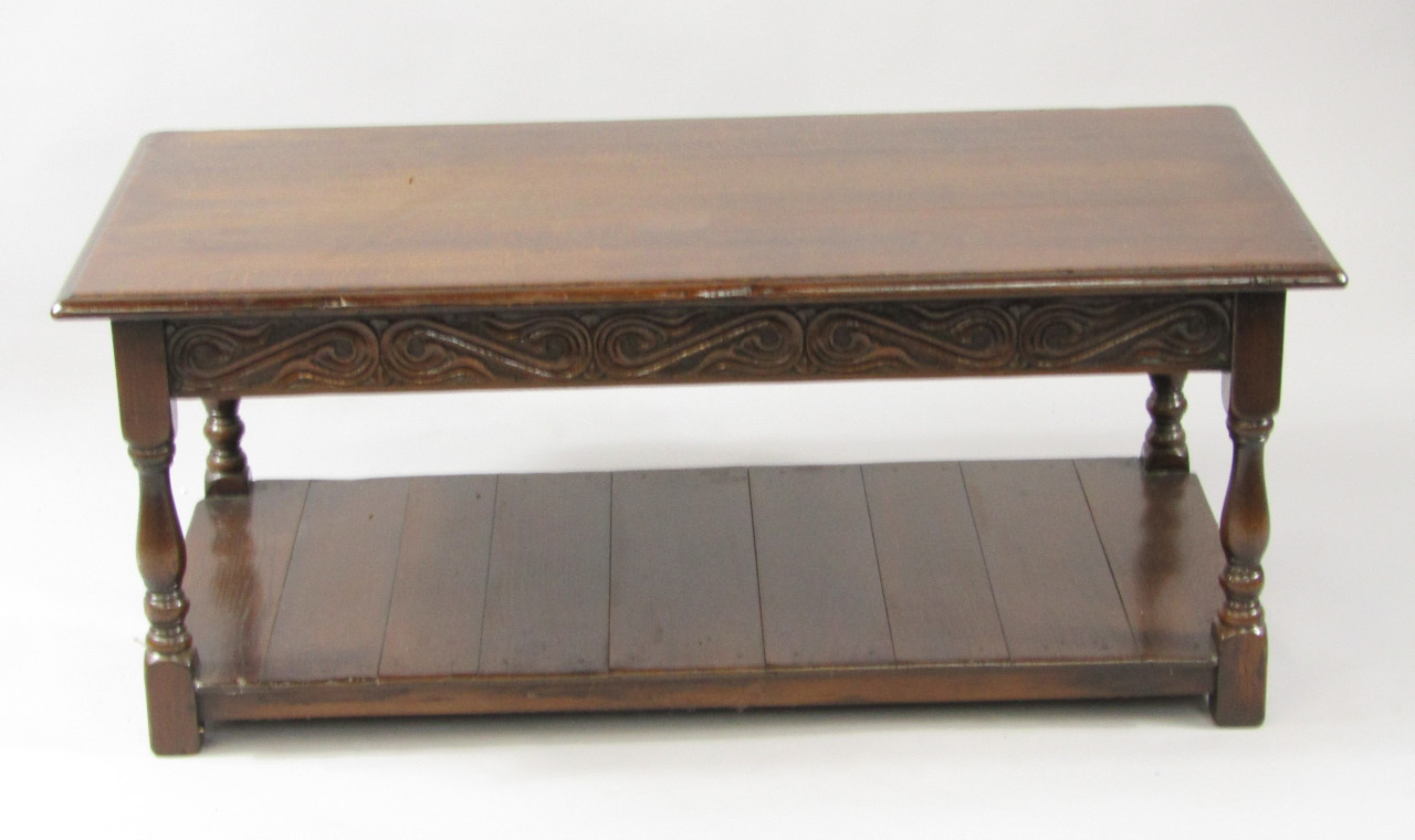 Appraisal: A rectangular oak occasional table with a carved leaf scroll