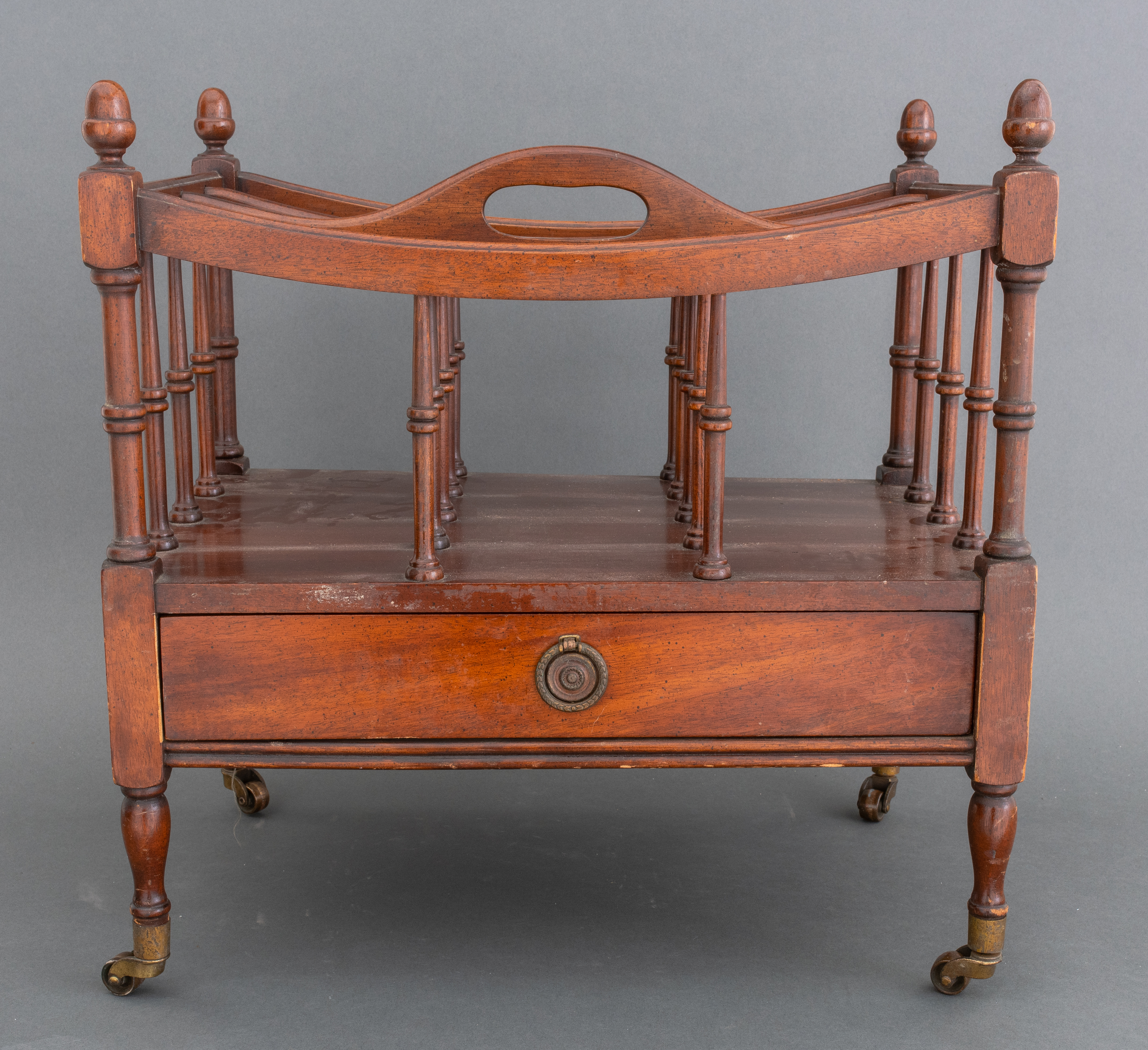 Appraisal: CANTERBURY MAGAZINE RACK ON CASTER WHEELS Antique hardwood Canterbury magazine