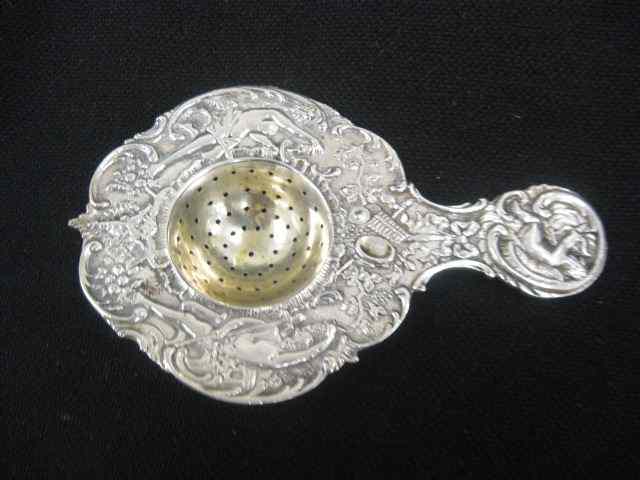 Appraisal: Dutch Sterling Silver Tea Strainer elaborate scene with cupid boy