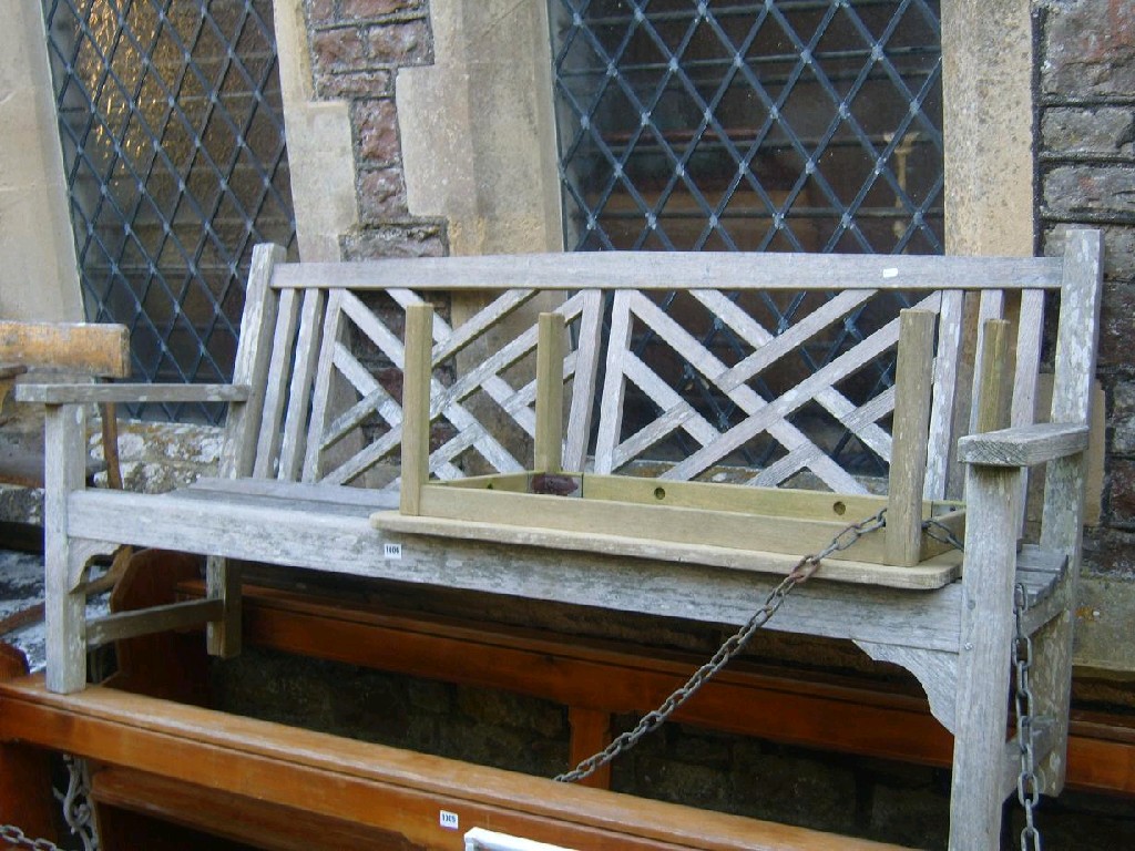 Appraisal: A teakwood garden bench with stylised back marked Lister Hailsham