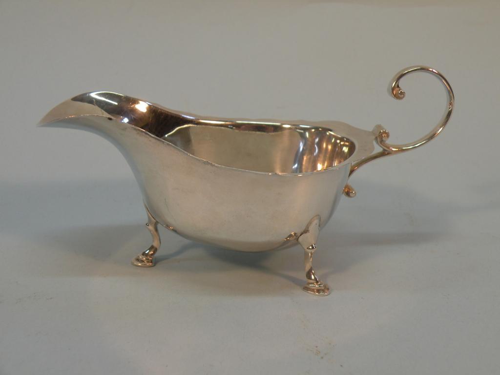 Appraisal: A silver cream jug with a scroll handle and three