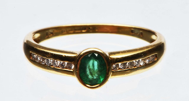 Appraisal: A CONTEMPORARY EMERALD AND DIAMOND SET DRESS RING oval faceted