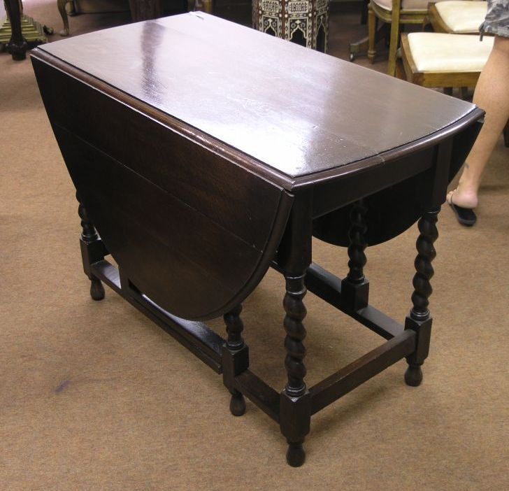 Appraisal: A solid dark oak gateleg dining table on barley twist