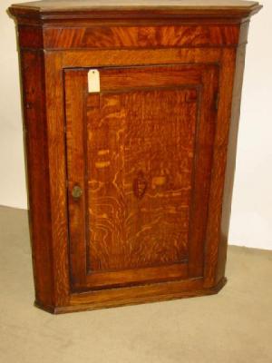 Appraisal: A GEORGE III OAK CORNER CUPBOARD with mahogany crossbanding stringing