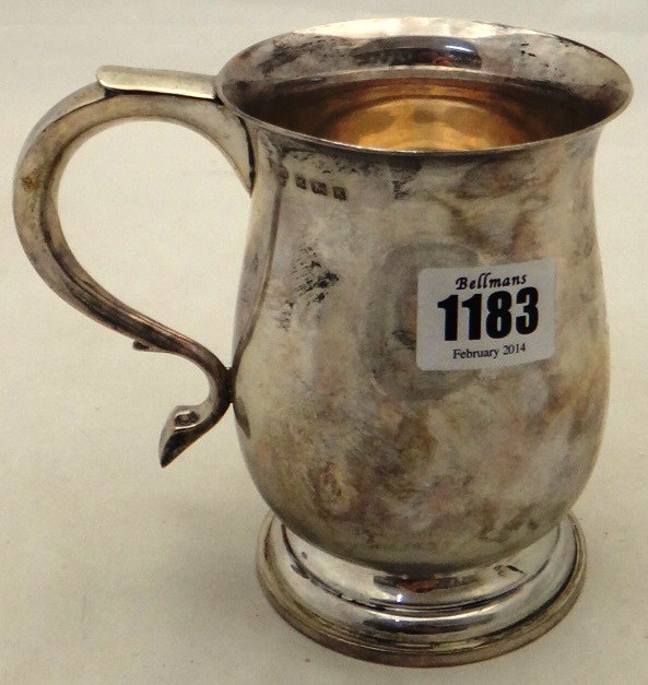 Appraisal: A silver mug of baluster form with a scrolling handle