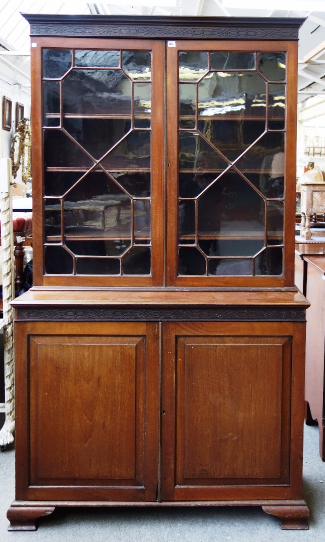 Appraisal: A George III mahogany bookcase cupboard with pair of astragal