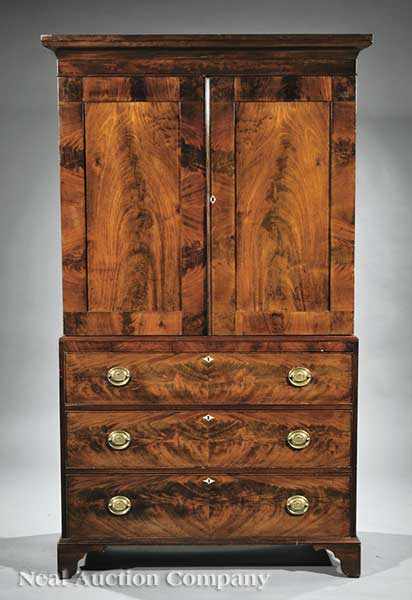 Appraisal: An Antique Georgian-Style Mahogany Linen Press having an ogee-molded cornice