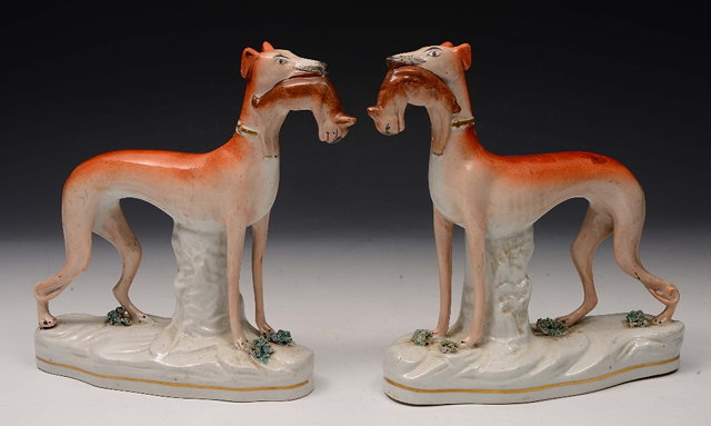 Appraisal: A PAIR OF VICTORIAN STAFFORDSHIRE POTTERY FIGURES of greyhounds each