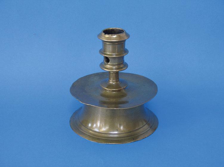 Appraisal: A BRONZE CAPSTAN CANDLESTICK with a ring-turned nozzle on a